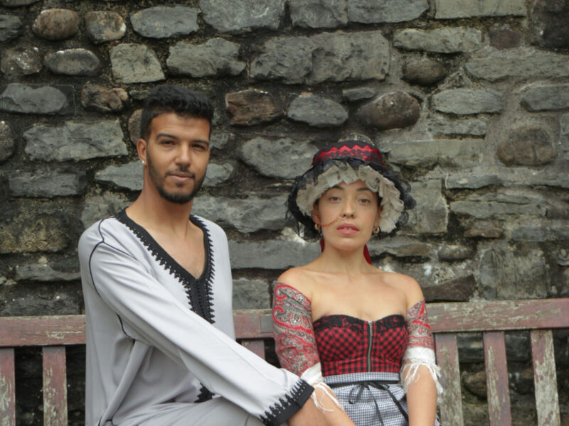 Ayoub & Ffion in traditional Moroccan & Welsh attire, sitting down